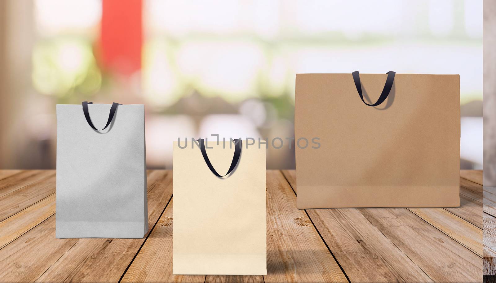 Three paper bags for shopping on a wooden background by boys1983@mail.ru