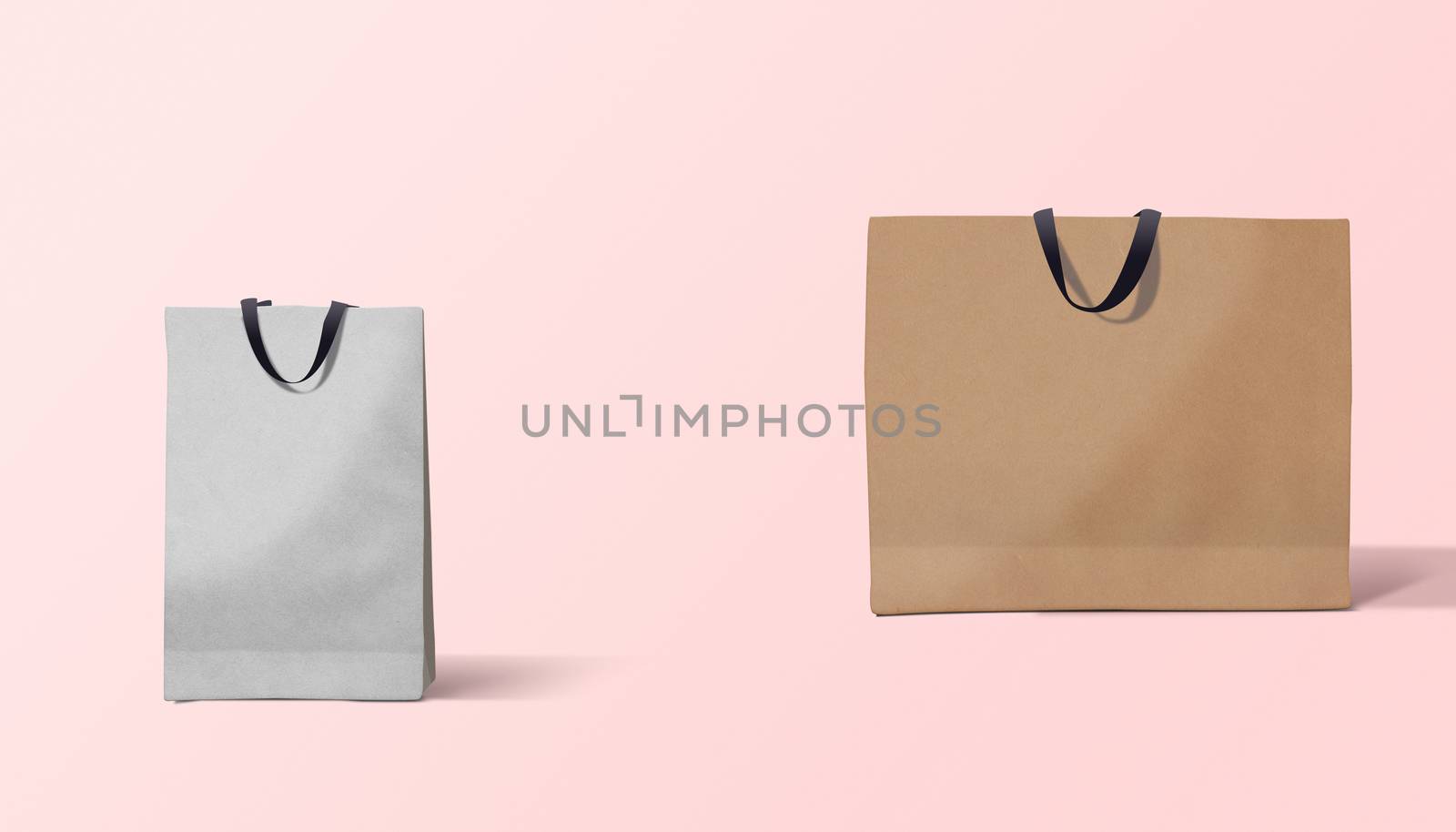 Two paper bags for shopping on a pink background
