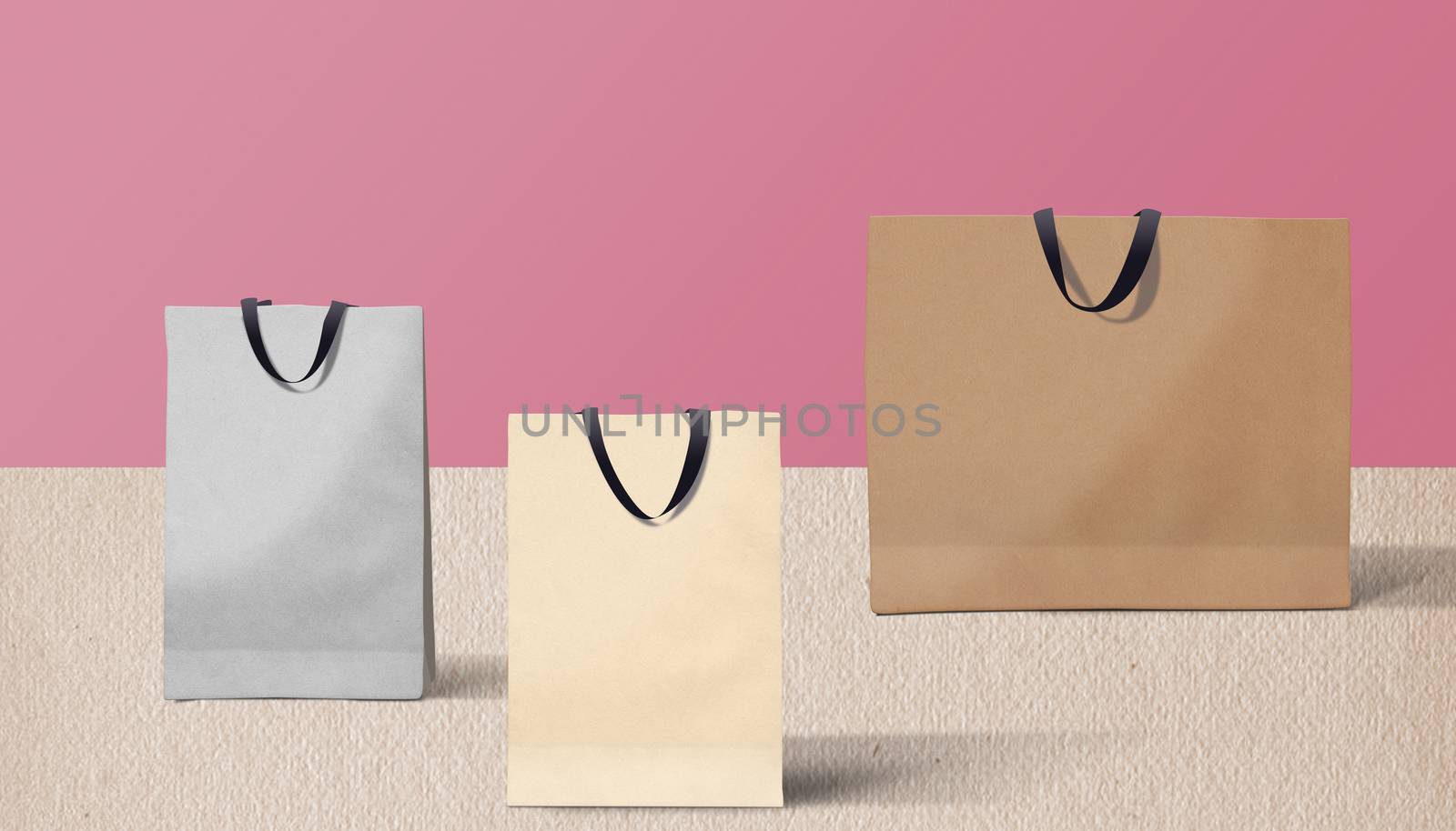 three paper bags for shopping on a pink background by boys1983@mail.ru