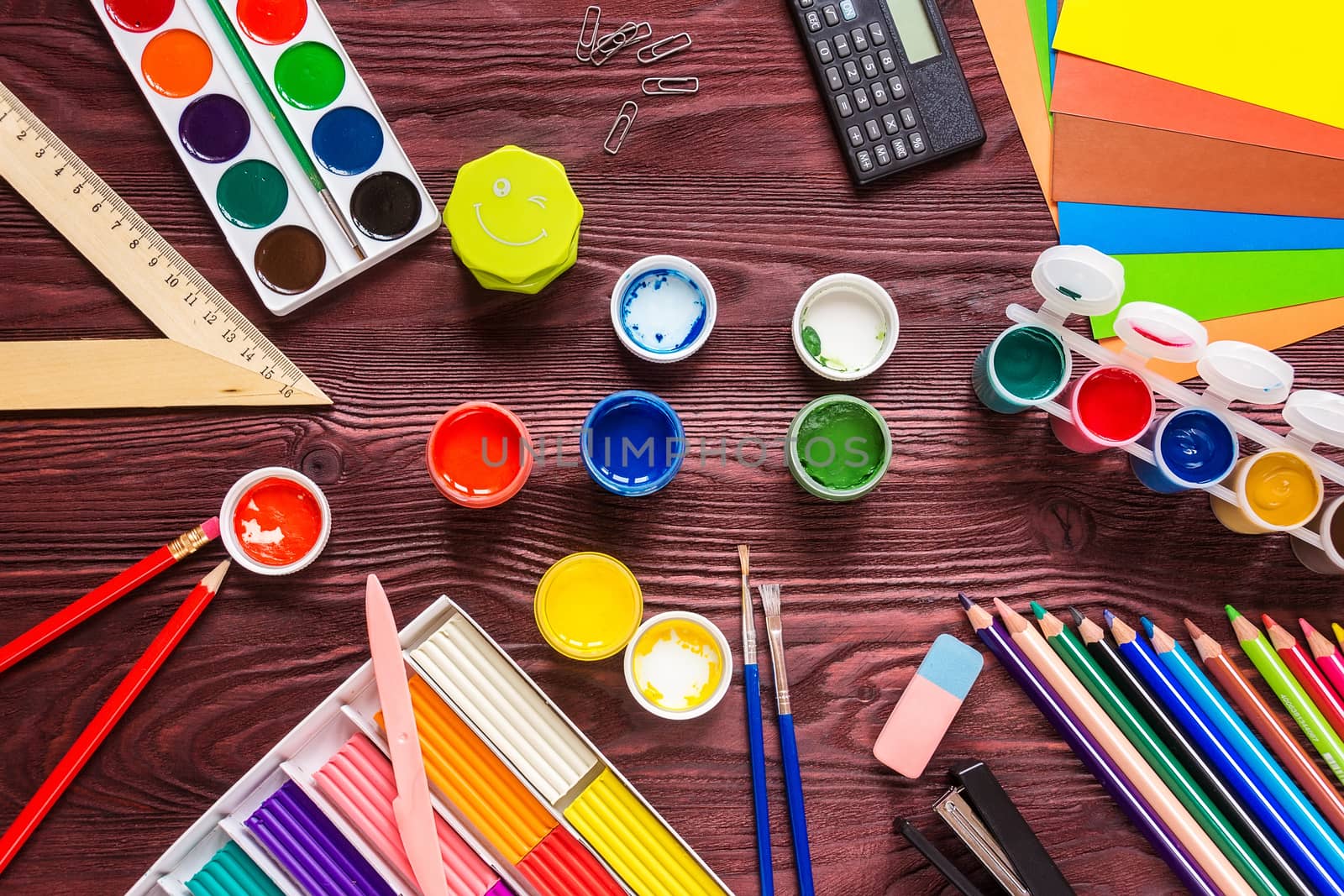 School supplies on a red background, paints and brushes