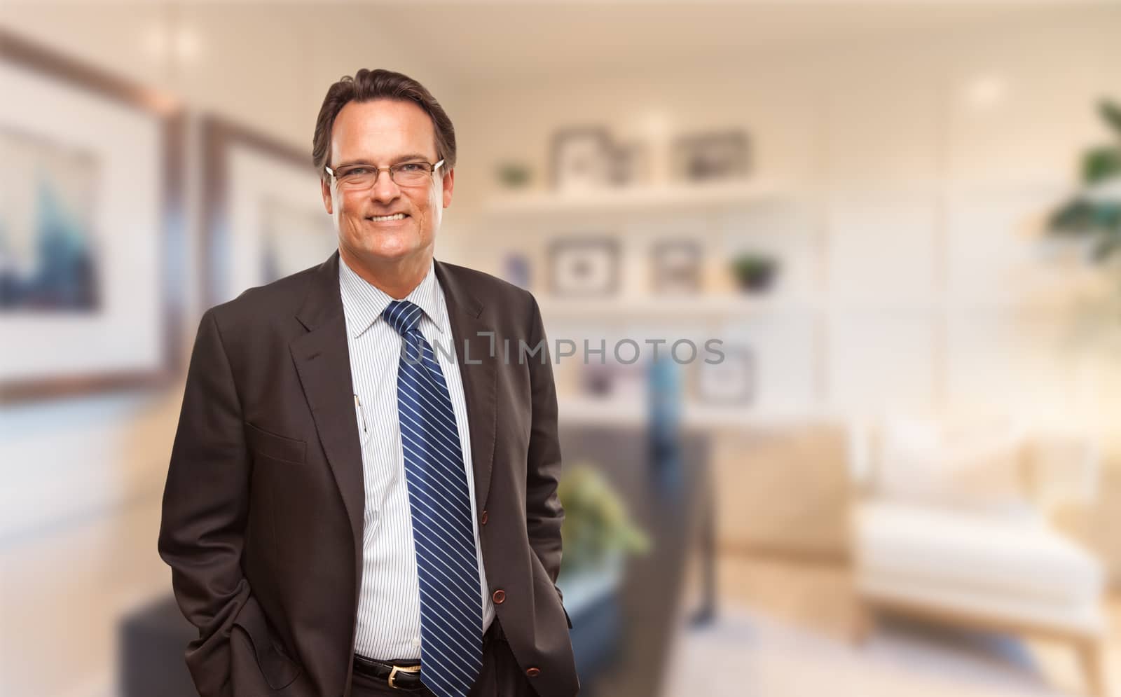 Handsome Businessman In Suit and Tie Standing in His Office.