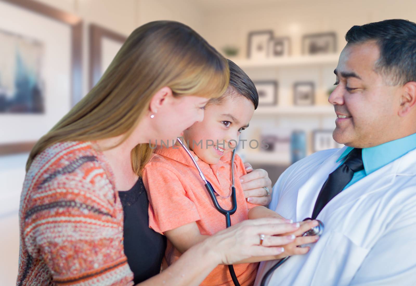 Young Boy and Mother Visiting with Hispanic Doctor in Office.