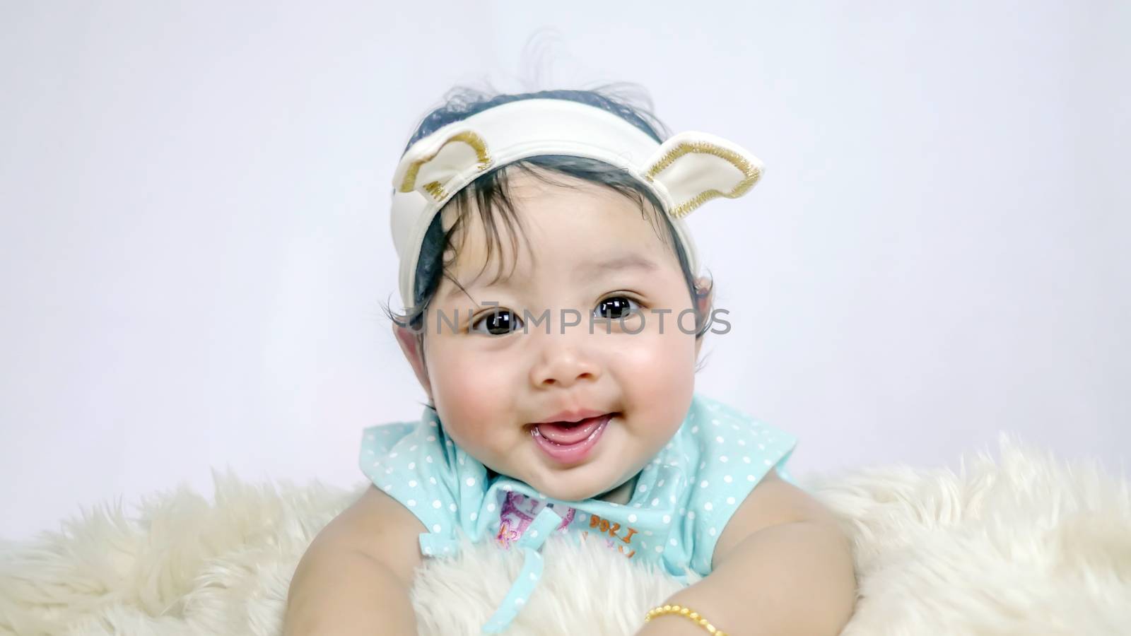 Asian Smiling baby girl crawling in bedroom