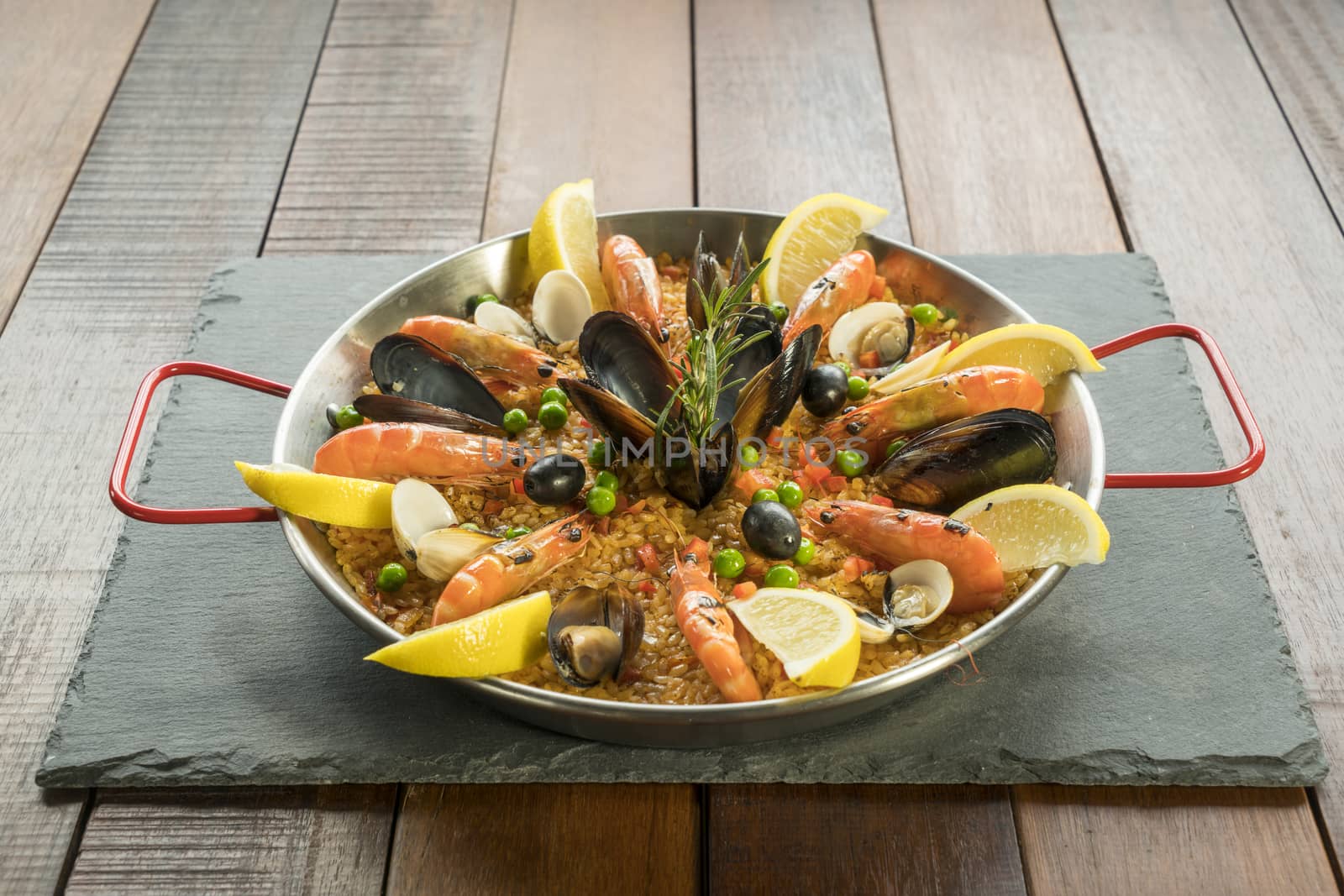 Paella with seafood vegetables and saffron served in the traditional pan