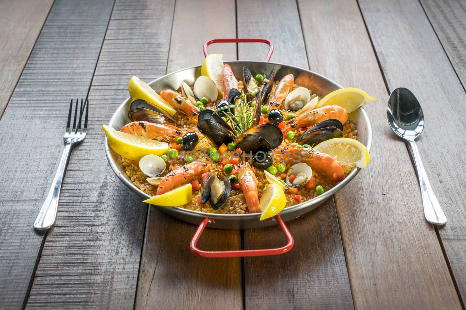 Paella with seafood vegetables and saffron served in the traditional pan