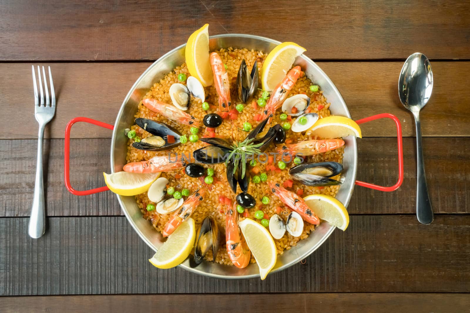 Paella with seafood vegetables and saffron served in the traditional pan.