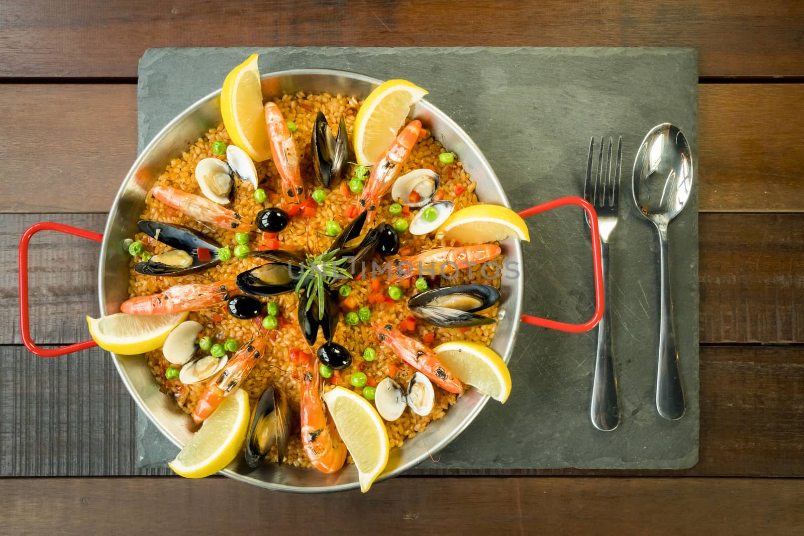 Paella with seafood vegetables and saffron served in the traditional pan.