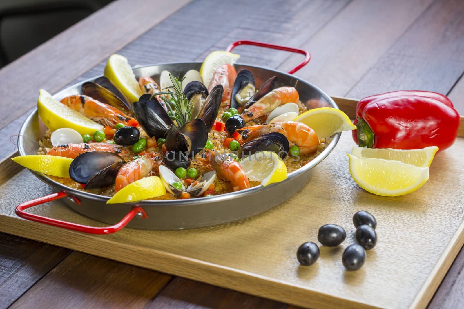 Paella with seafood vegetables and saffron served in the traditional pan.