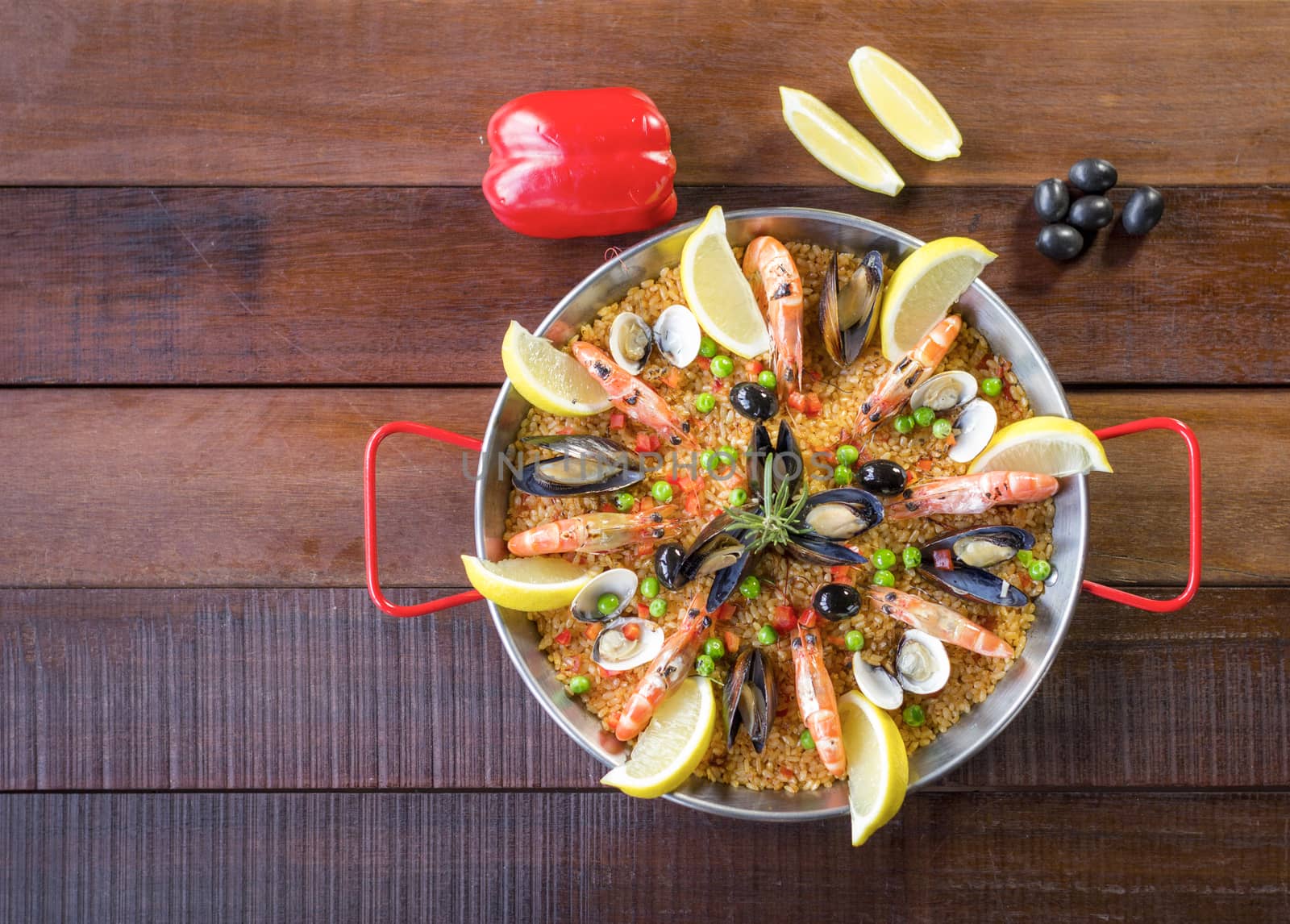 Paella with seafood vegetables and saffron served in the traditional pan.