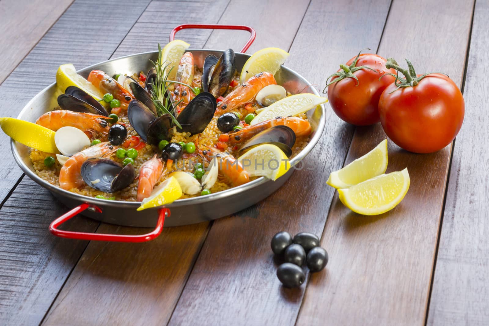 Paella with seafood vegetables and saffron served in the traditional pan.