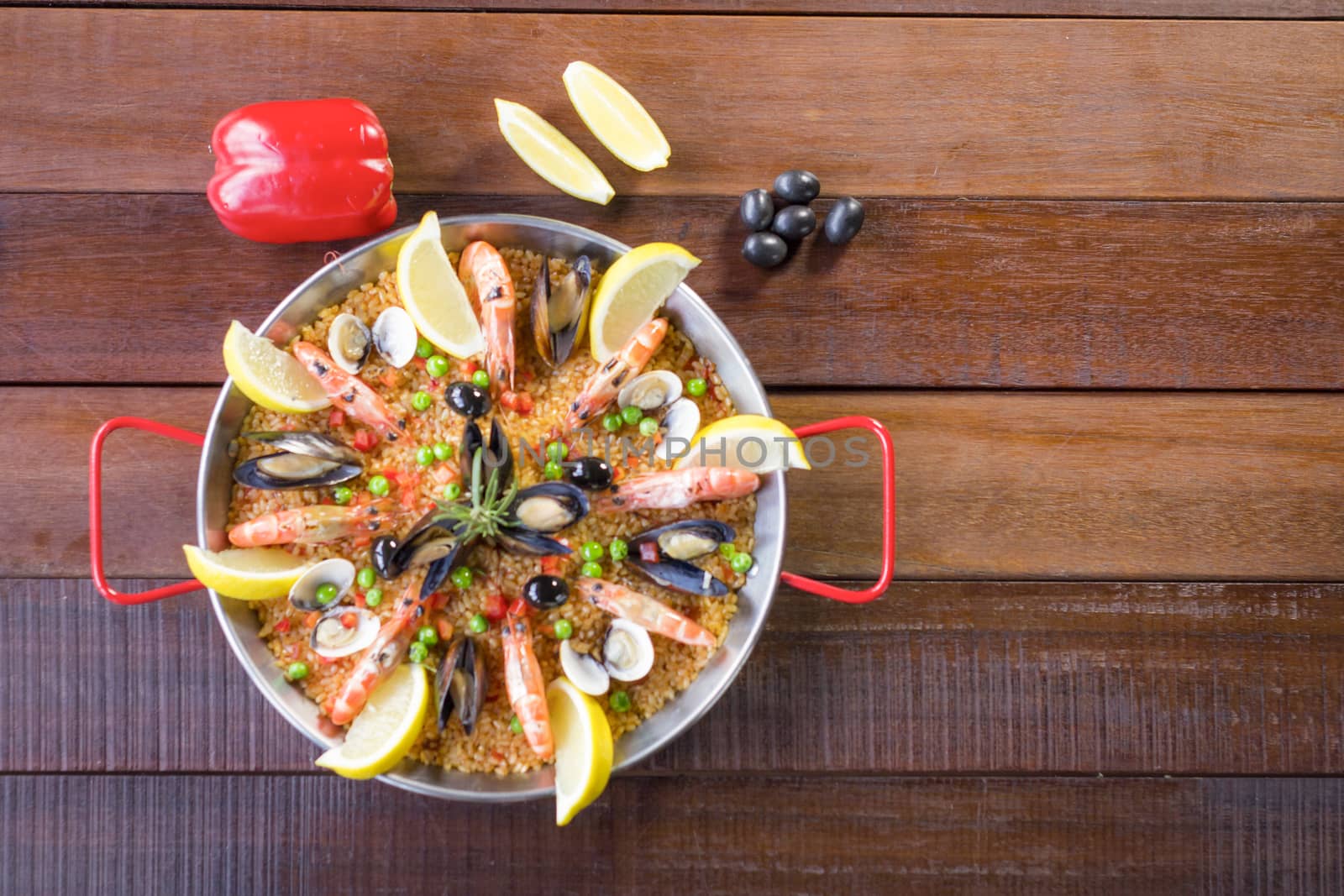 Paella with seafood vegetables and saffron served in the traditional pan.