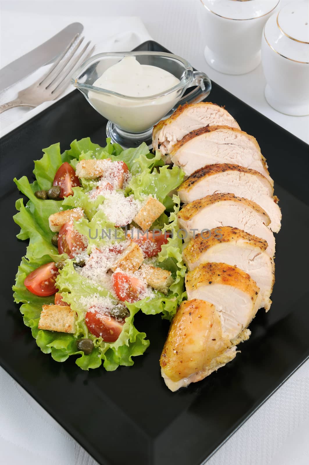 Sliced baked chicken breast with garnish  a la Caesar. 