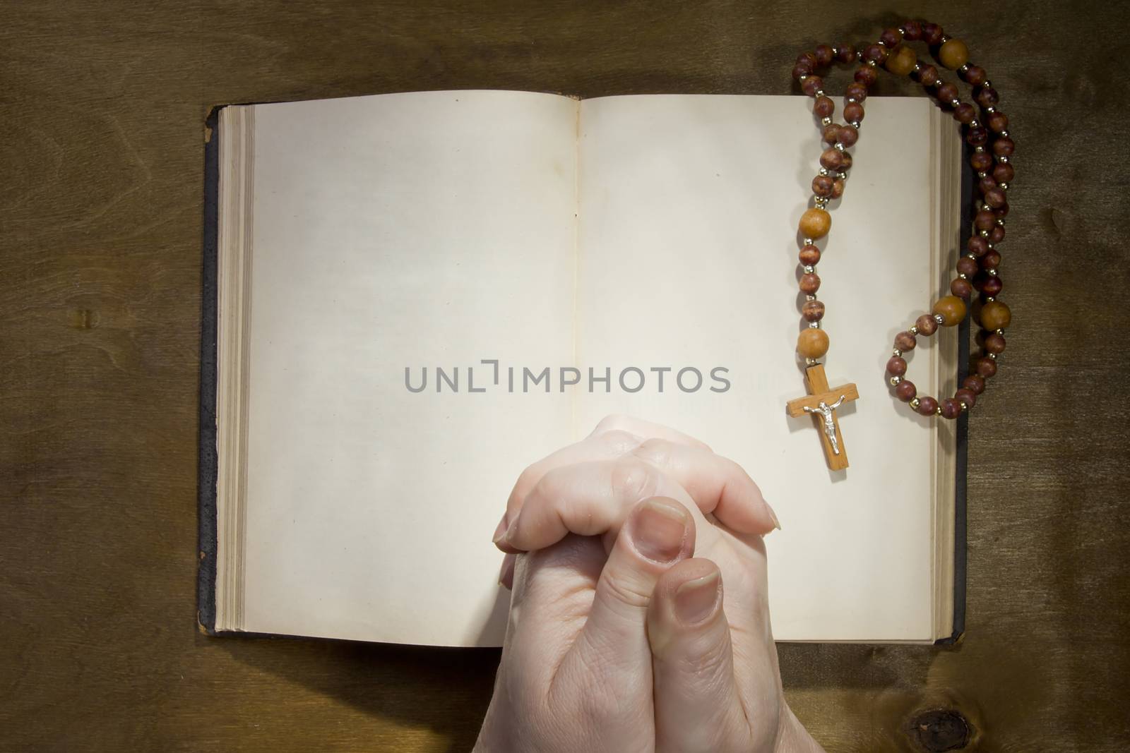 Hands with rosary and an old book by VIPDesignUSA