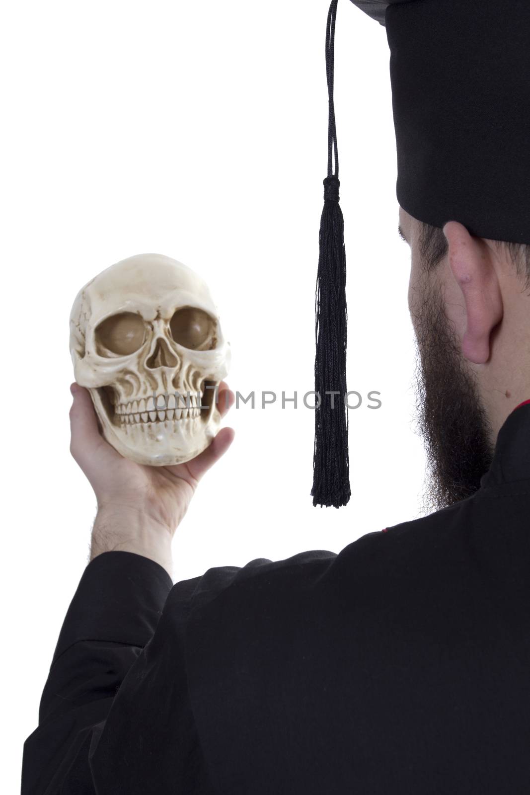 Young man in a graduate cap with a skull on a white background