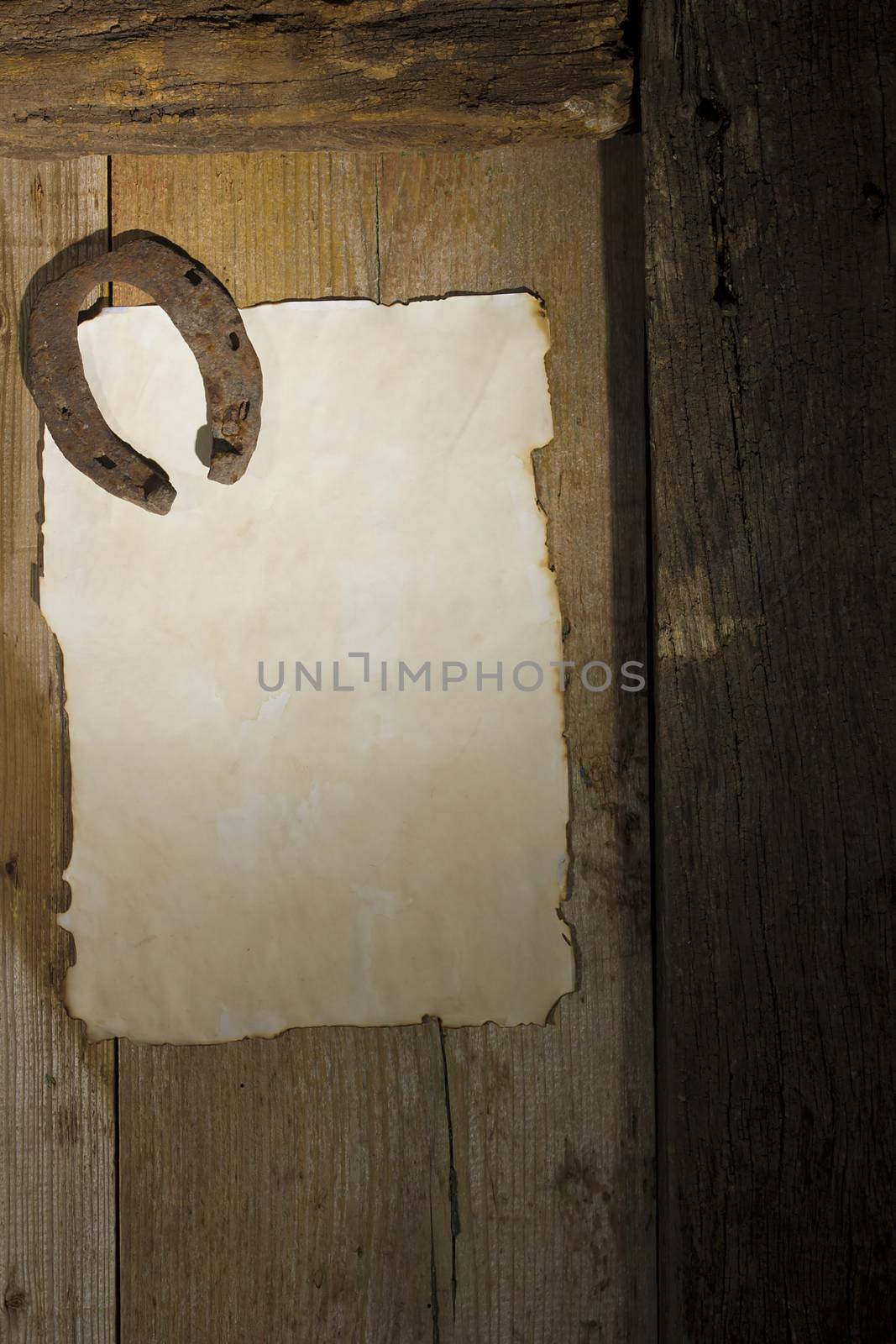 Rusty horseshoe and a sheet of paper on an antique door