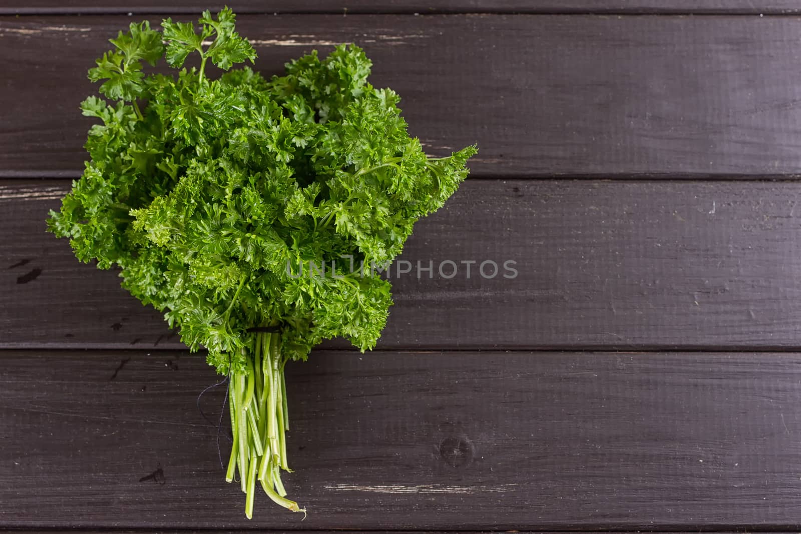 Fresh basil greens, parsley on a black background. Dark rustic style.