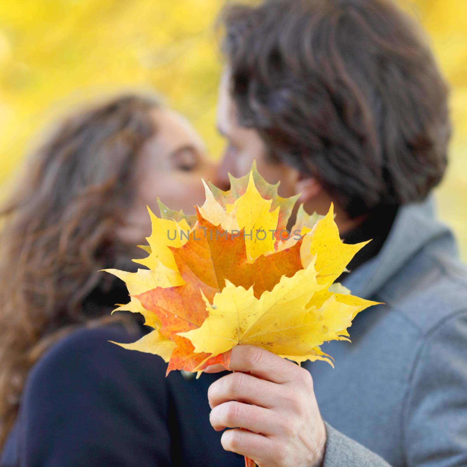 Love, relationship, family and people concept - couple kissing in autumn park