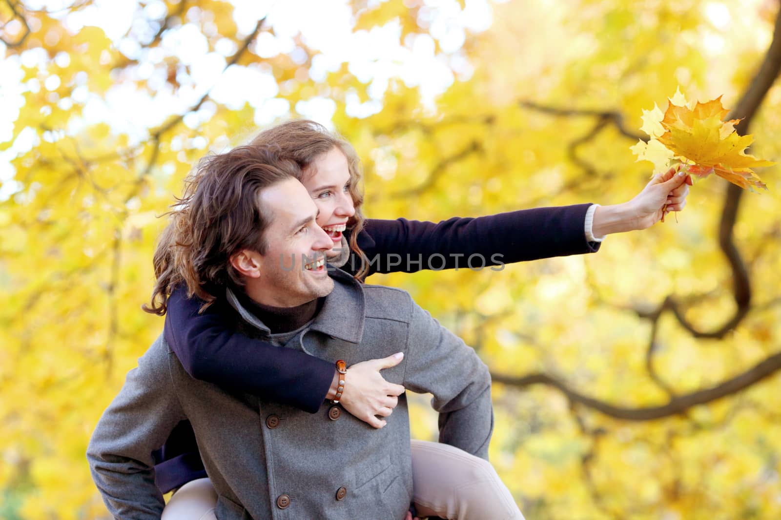 Couple having fun in autumn park by ALotOfPeople