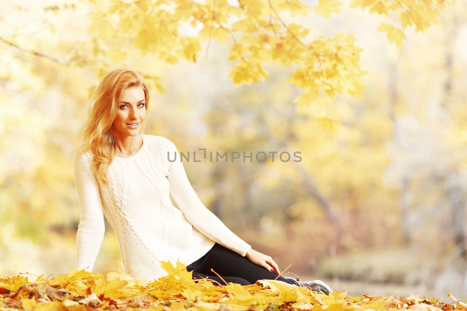 Woman sitting in autumn park by Yellowj