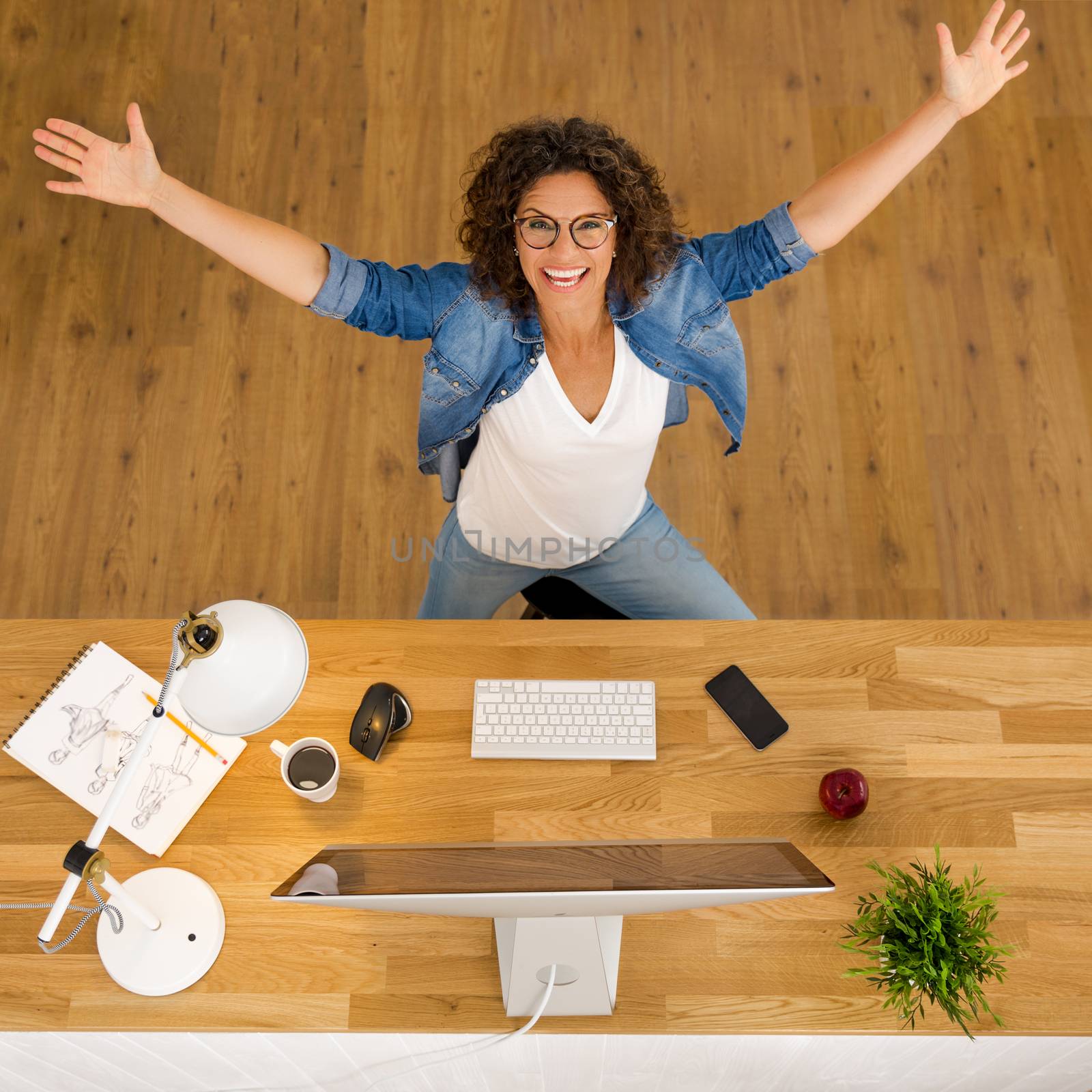 Top view of a happy businesswoman with arms open at the office