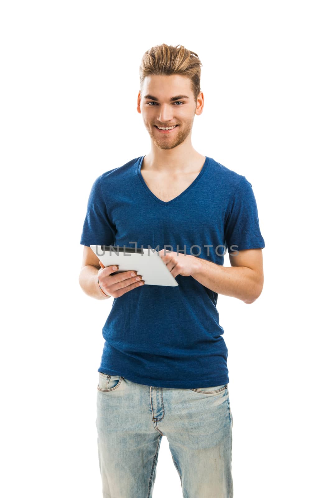 Handsome young man holding and working with a tablet 