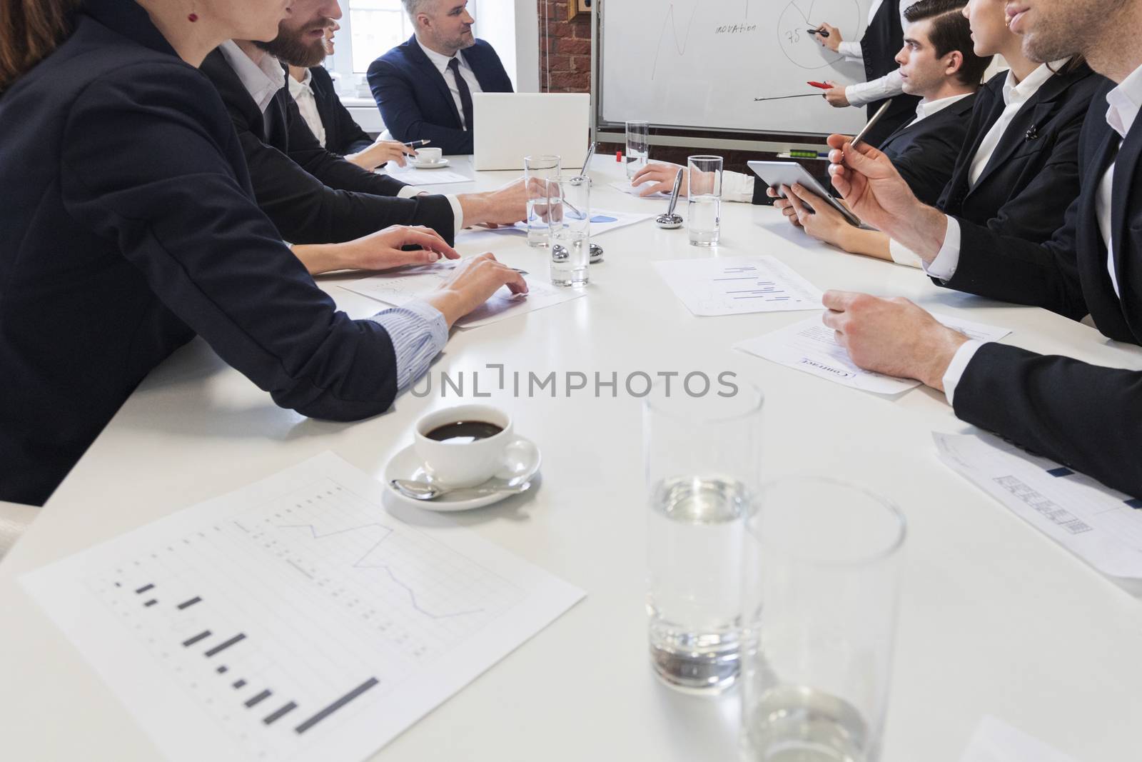 Business people at meeting table work with documents and financial data together