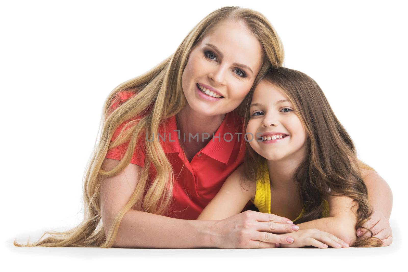 Happy smiling mother and daughter laying on floor, studio portrait isolated on white background