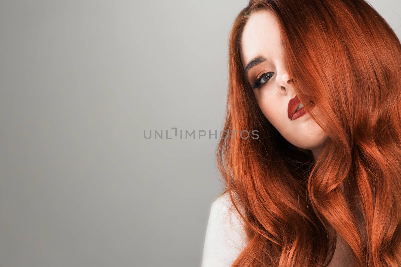 Readhead woman beauty studio portrait on gray background