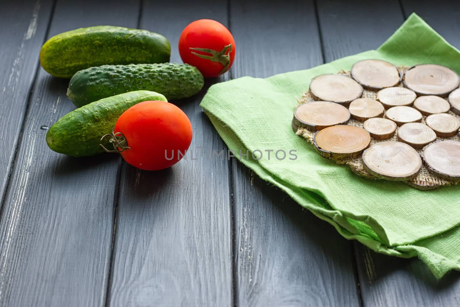 Tomatoes and cucumber on the black wood background