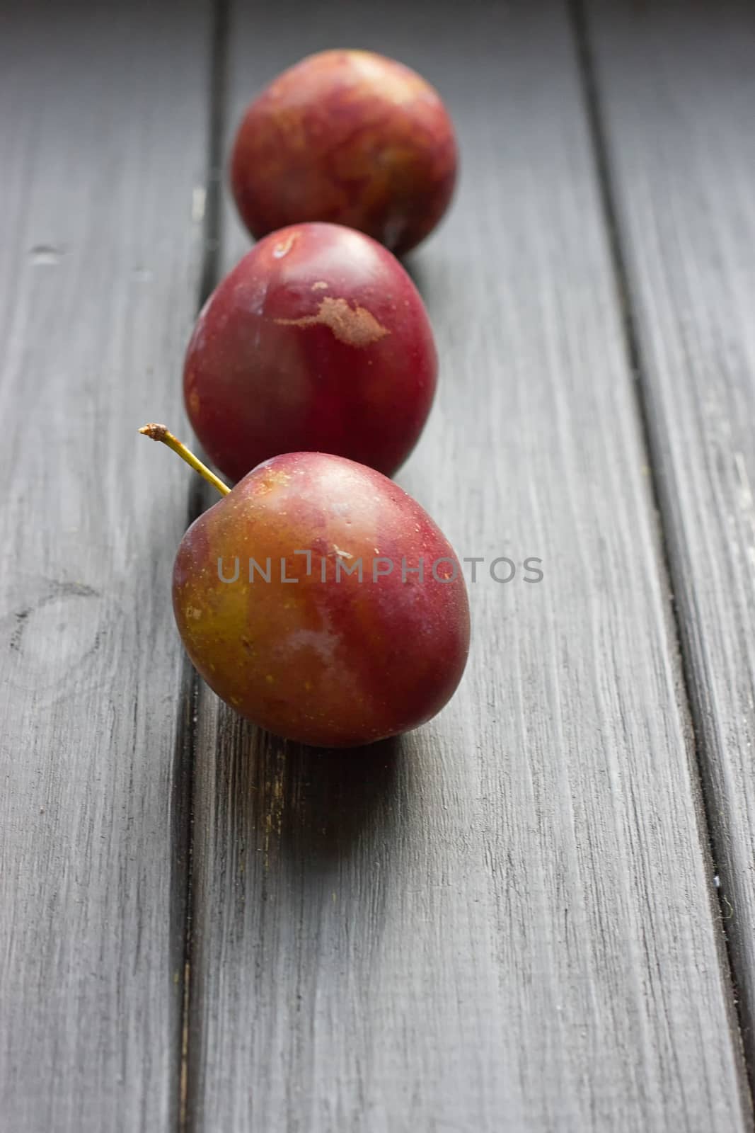 fresh plums on the black wooden table