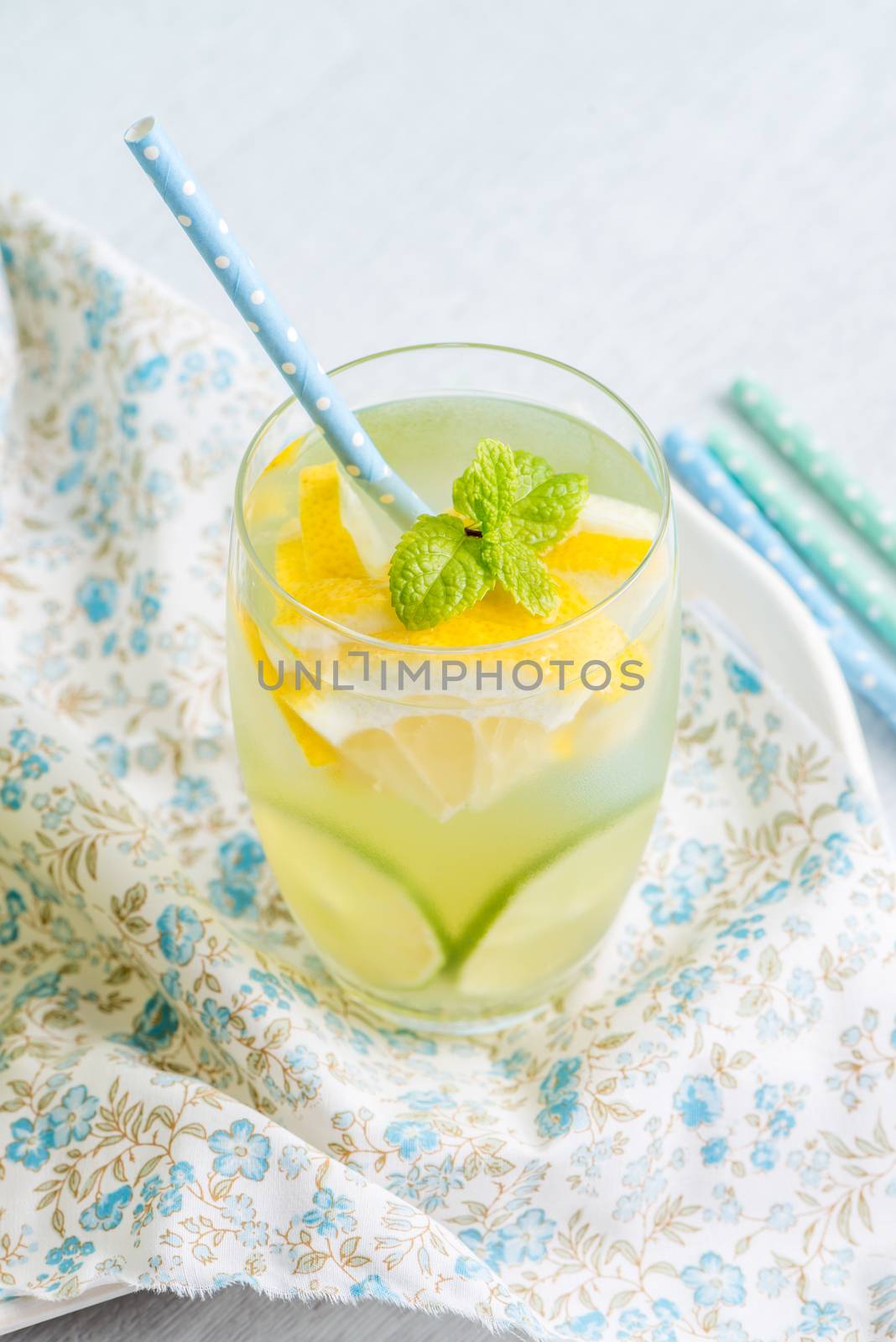 Summer citrus fruits drink on wooden background. Detox citrus infused flavored water. Refreshing summer homemade cocktail with lemon. Fresh lemon and lemonade on wooden background