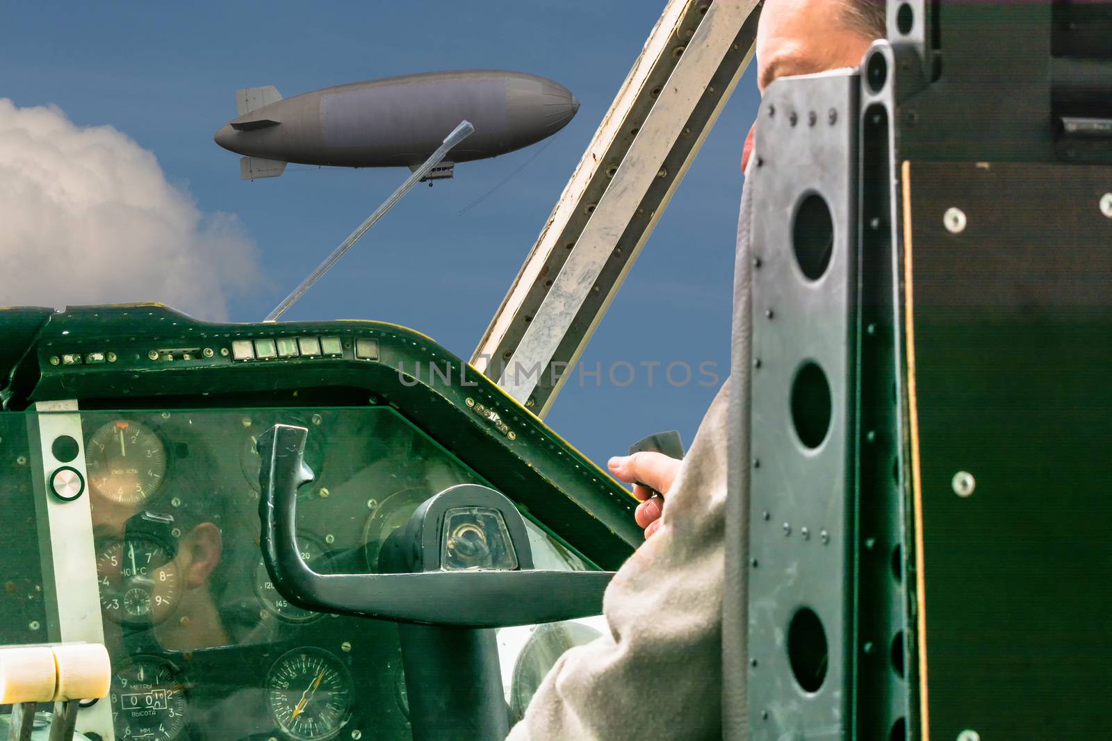 In the cockpit of an old propeller aircraft. Through the cockpit disk you can see a zeppelin passing by.