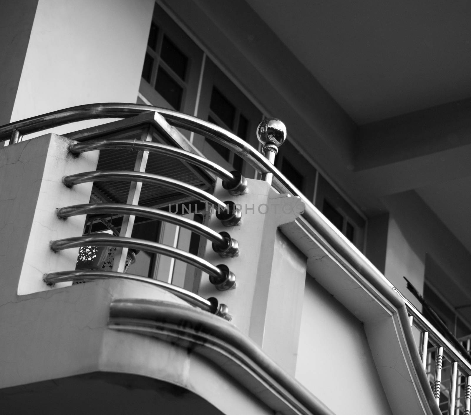 BLACK AND WHITE PHOTO OF CURVING STAINLESS STEEL HANDRAIL