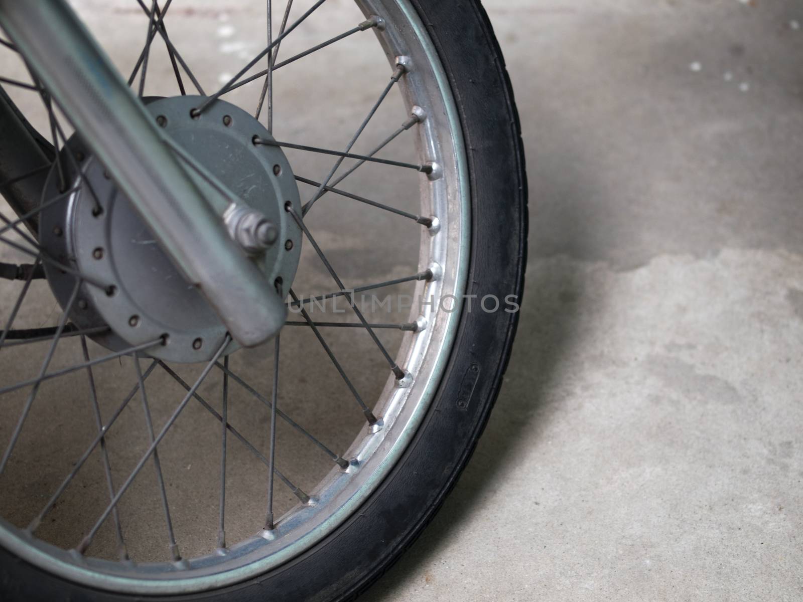 COLOR PHOTO OF CLOSE-UP OF MOTORCYCLE SPOKES AND WHEEL