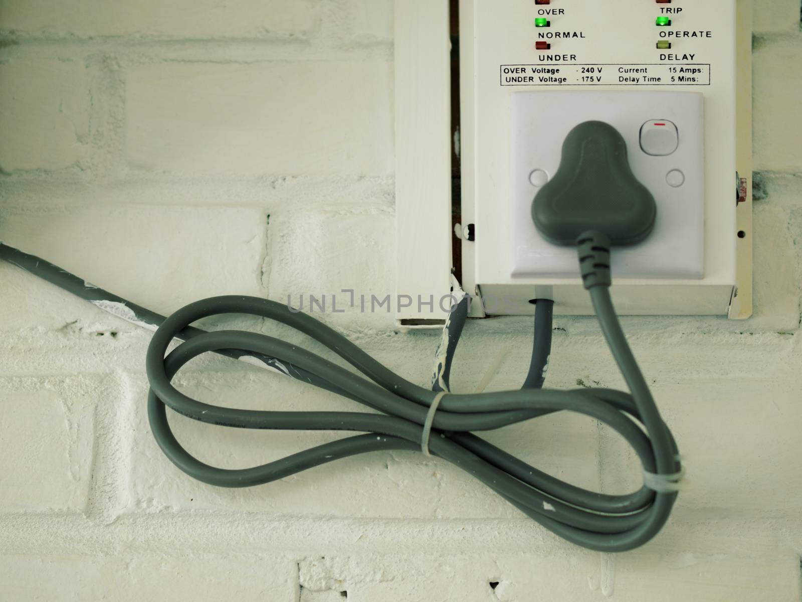 COLOR PHOTO OF ELECTRICAL CABLE ON WHITE BRICK WALL