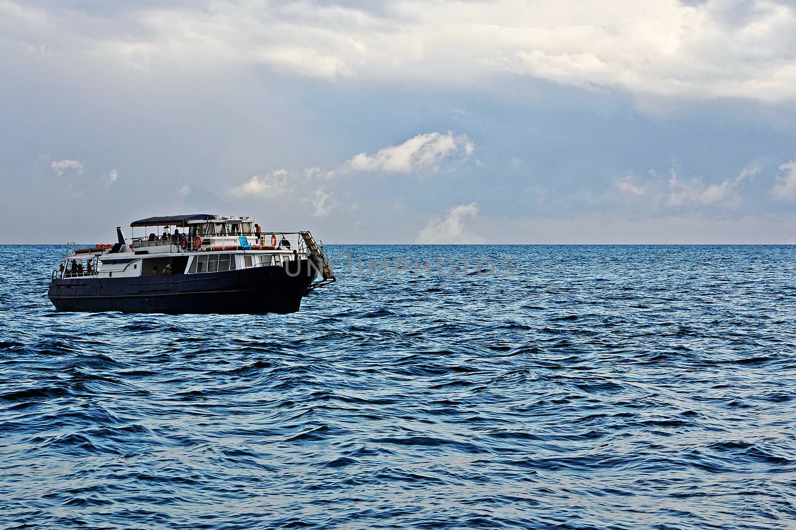 A small pleasure passenger sea ship in the boundless sea.