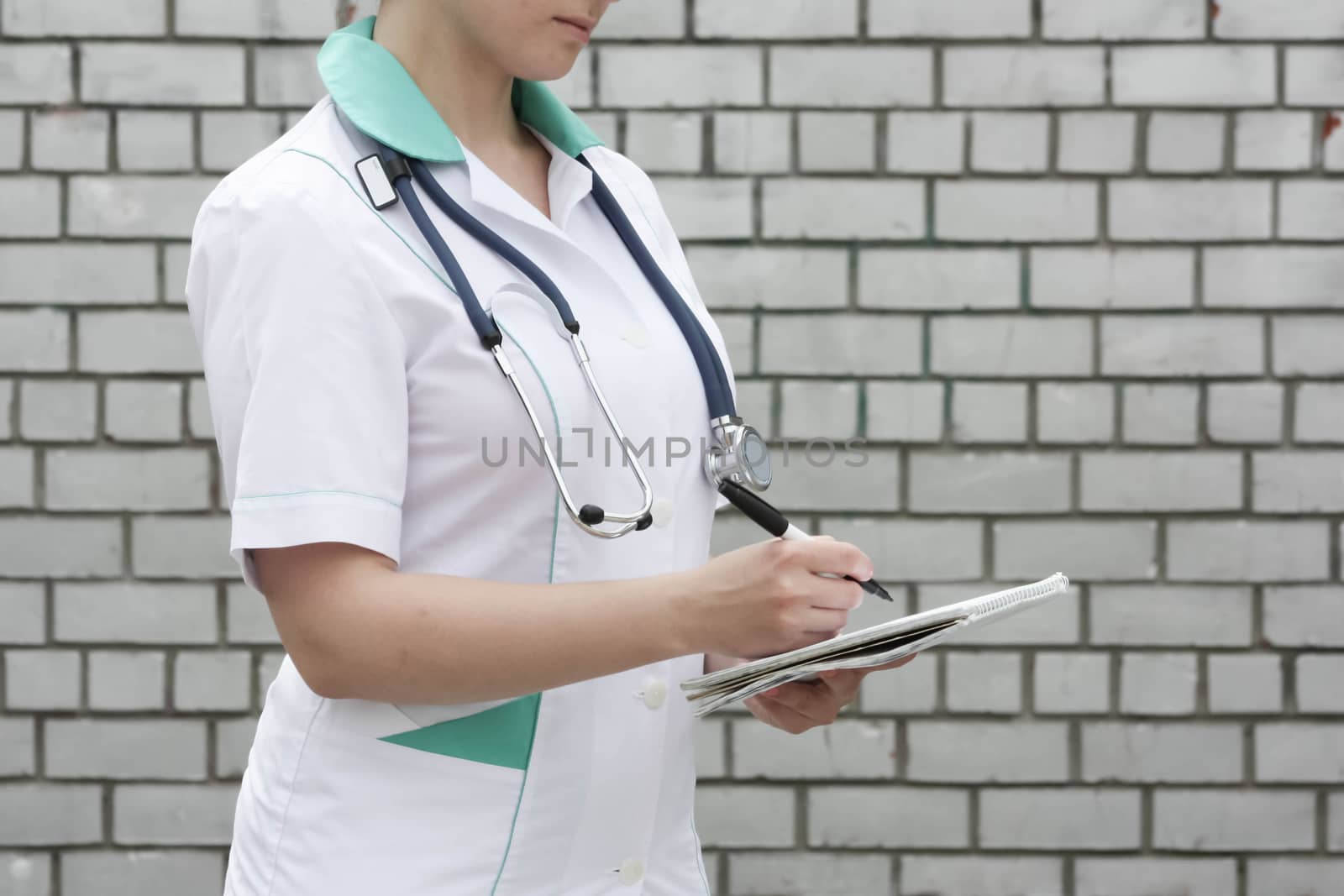 Medicine concept doctor. collection of information. A woman is holding a paper notebook and a pen. In the profile. Photo for your design