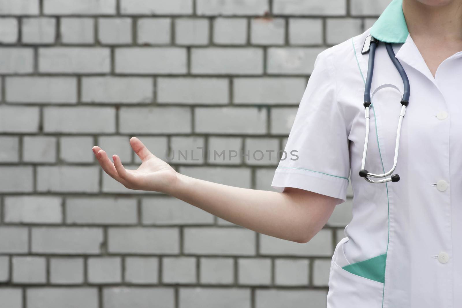 Medicine concept doctor. collection of information. The woman holds her hand palm up. Against a brick wall background. Photo for your design