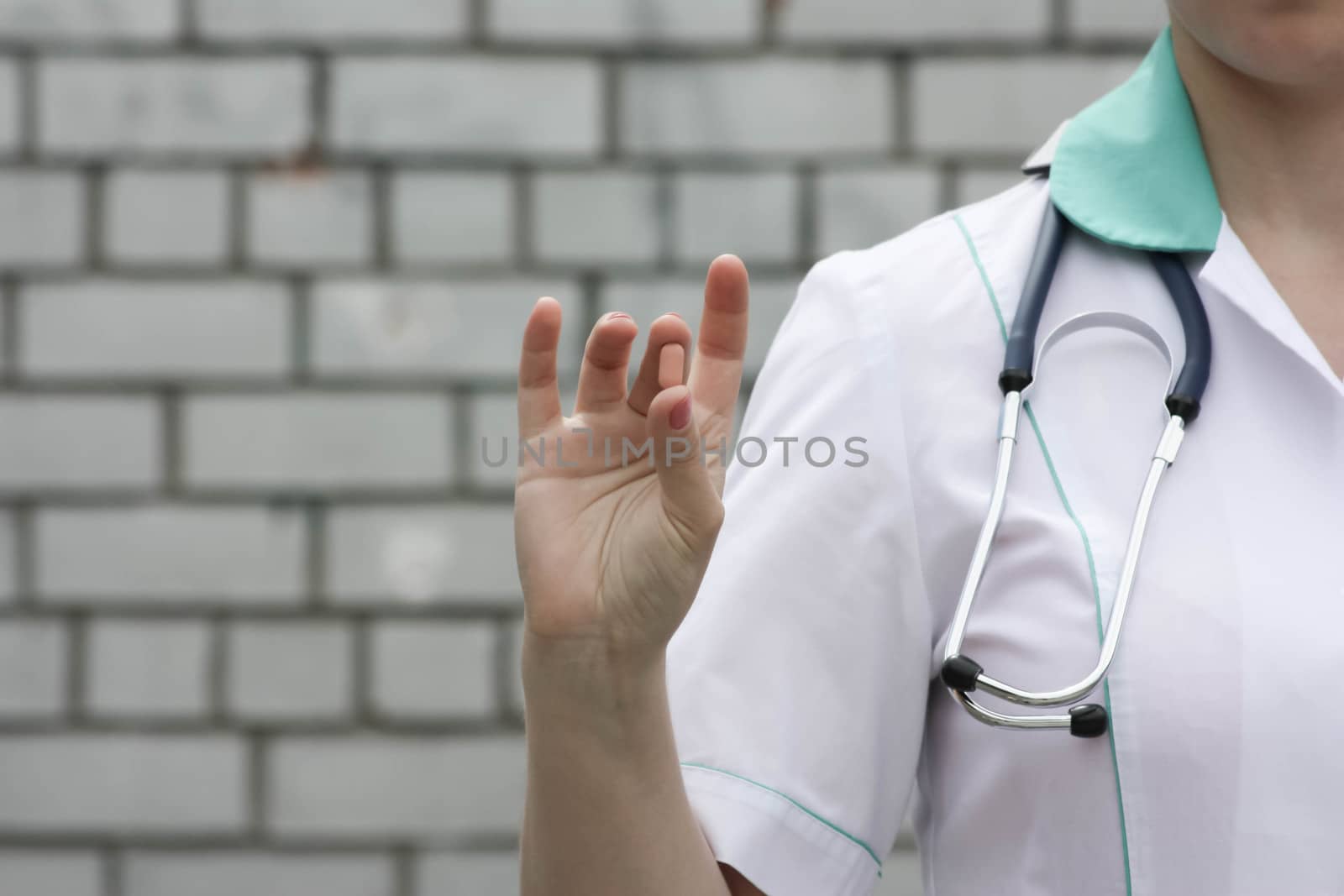 Medicine concept doctor. On a white brick wall background. Holds a pink pill. Advertising products. Photo for your design