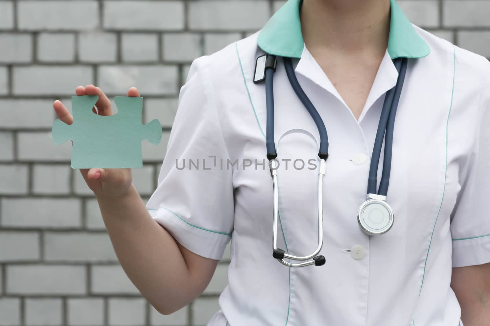 Medicine concept doctor. On a white brick wall background. system. Holds the puzzle one