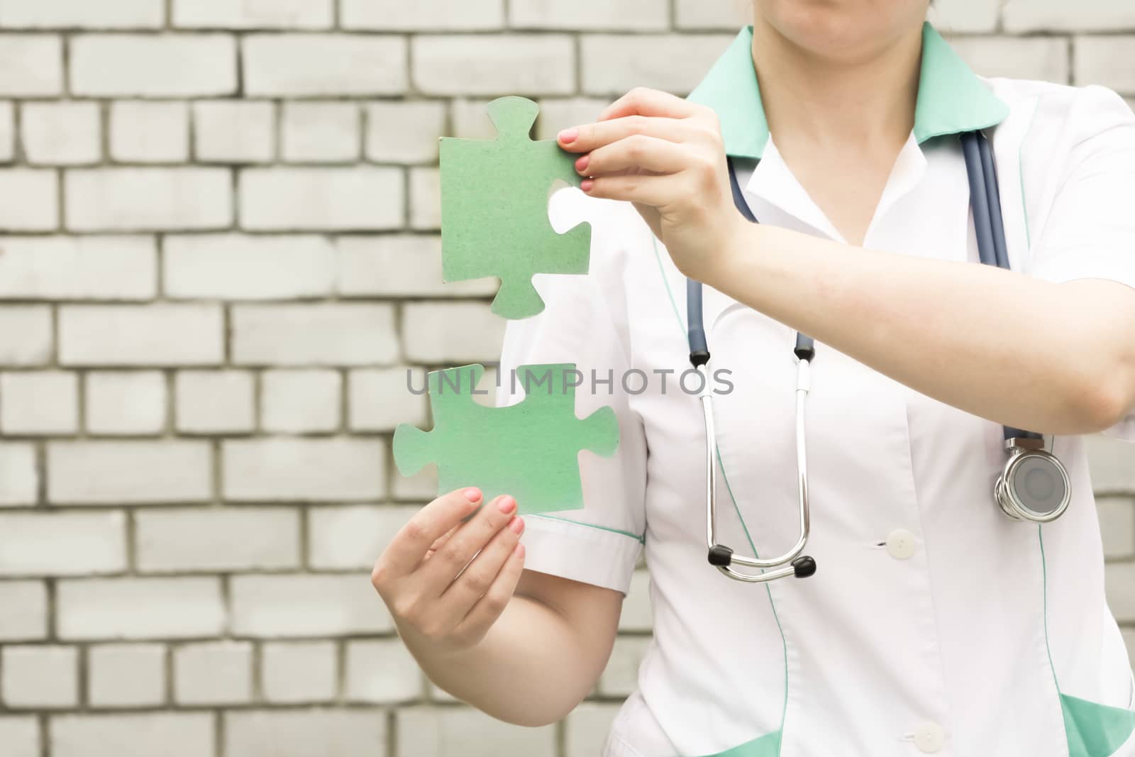 Medicine concept doctor. On a white brick wall background. system. Holds the puzzle two. Photo for your design