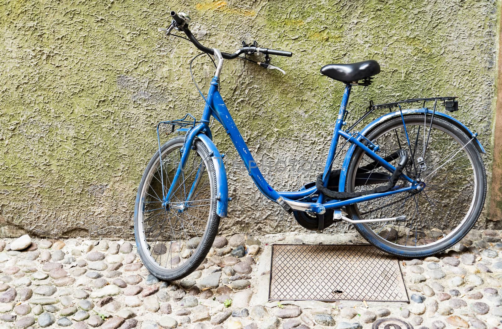 Old bicycle parked on a building wall in Ravenna, Italy