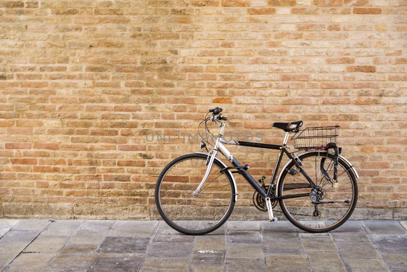 Old bicycle parked on a building wall in Ravenna, Italy