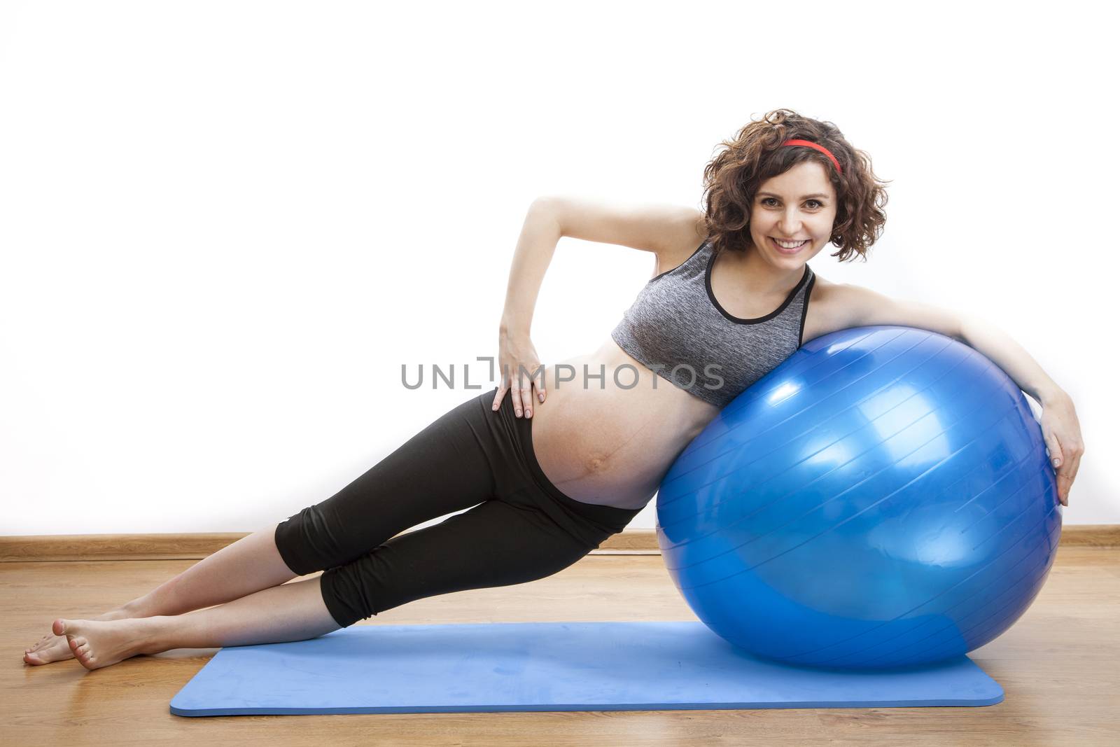 Young pregnant woman exercises with the ball.