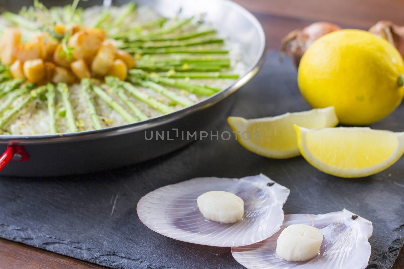 Paella with scollops and asparagus in traditional pan. 