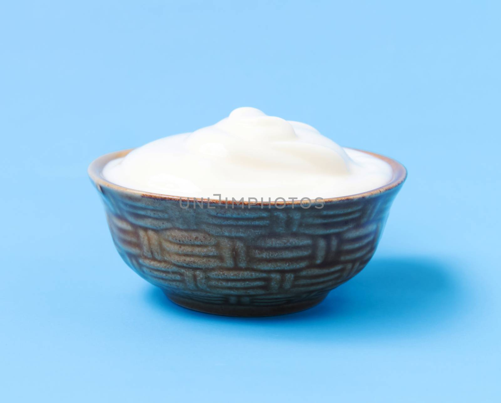 Greek yogurt in bowl with blue background by pt.pongsak@gmail.com