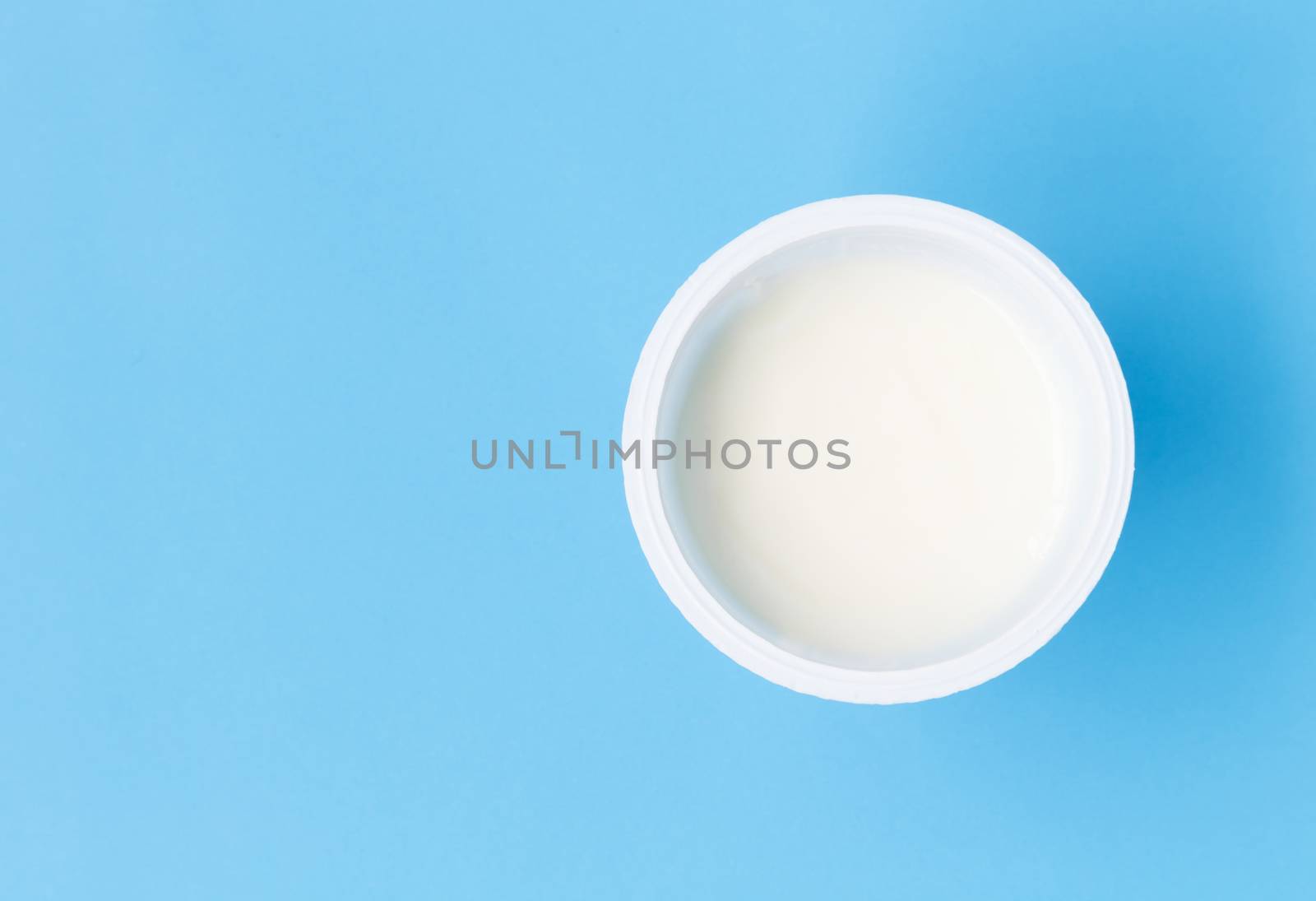 Closeup top view greek yogurt in white cup with blue background by pt.pongsak@gmail.com