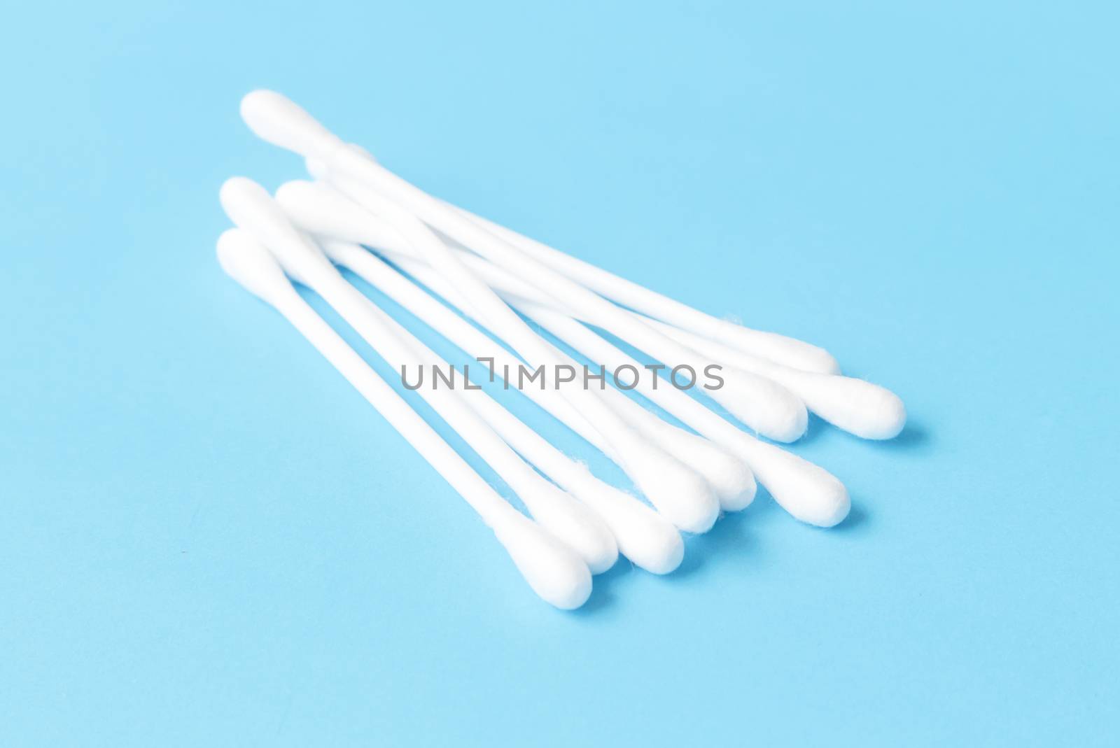 Cotton buds on light blue background, health care concept