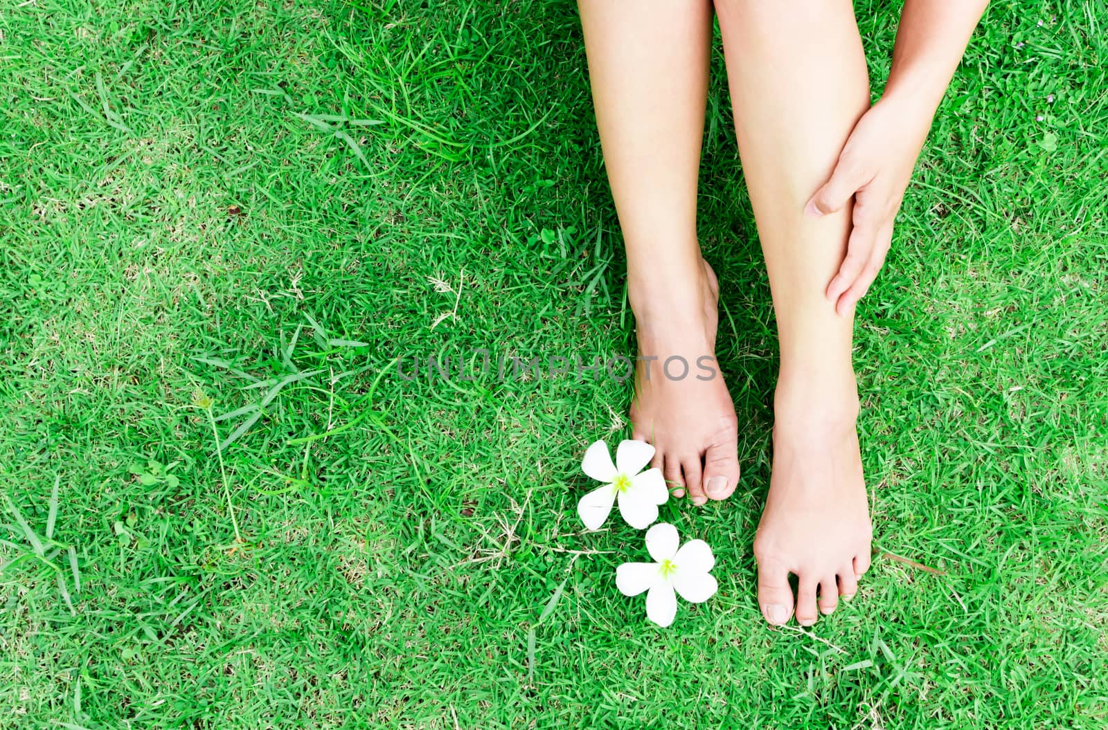 Woman legs relax feeling on green grass background with light of by pt.pongsak@gmail.com
