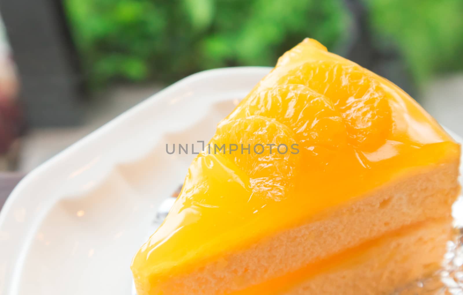 Closeup orange cake on wood table with nature background